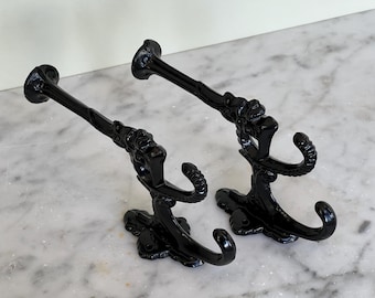 Par de percheros dobles antiguos de hierro fundido de la época victoriana.