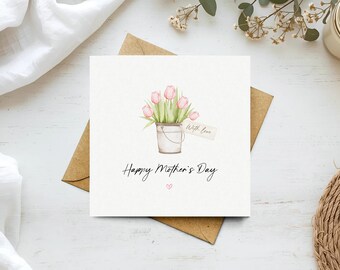May include: A square greeting card with a watercolor illustration of pink tulips in a metal bucket. The card reads "Happy Mother's Day" in script, with a small heart. A tag reads "With love". The card is on a brown envelope.