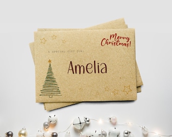 May include: A stack of kraft paper gift cards with a Christmas theme. The cards feature a green Christmas tree, gold stars, and the text "Merry Christmas!" and "A special gift for: Amelia."