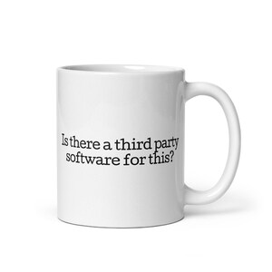Peut inclure: Une tasse à café en céramique blanche avec du texte noir qui dit "Y a-t-il un logiciel tiers pour ça ?"