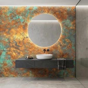May include: Modern bathroom design featuring a large round mirror with a backlit frame. The wall behind the mirror has a textured, multi-colored finish in shades of orange, green, and brown. A floating vanity with a white sink and black fixtures completes the contemporary look.