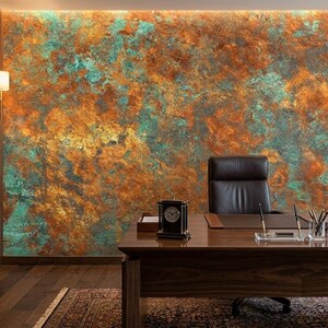 May include: An office interior featuring a large wooden desk, a black leather chair, and a textured wall with orange, teal, and gold tones. A clock, desk lamp, and computer are on the desk. Bookshelves and a patterned rug complete the scene.