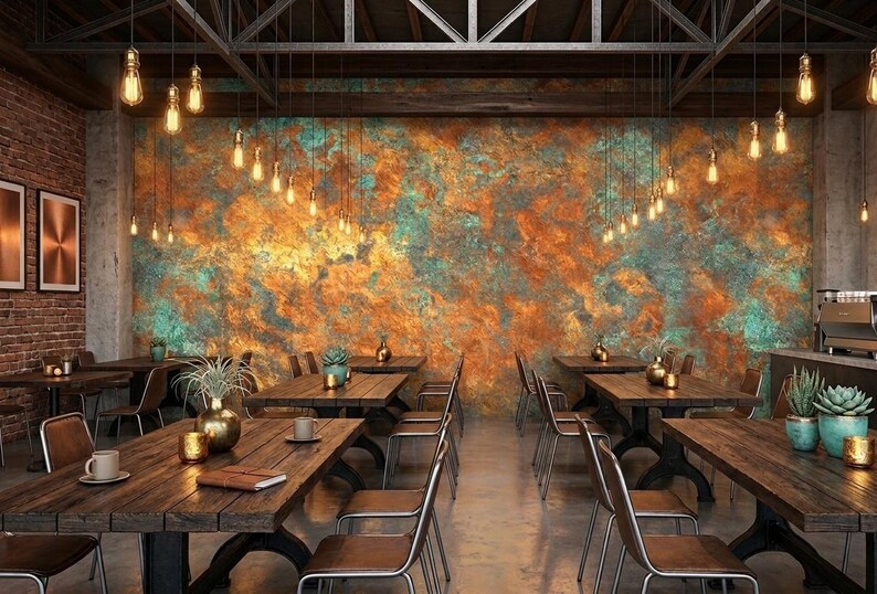 May include: Interior shot of a restaurant with wooden tables and chairs. The walls are decorated with a textured, colorful mural. Hanging lights illuminate the space. The overall theme is rustic and industrial.