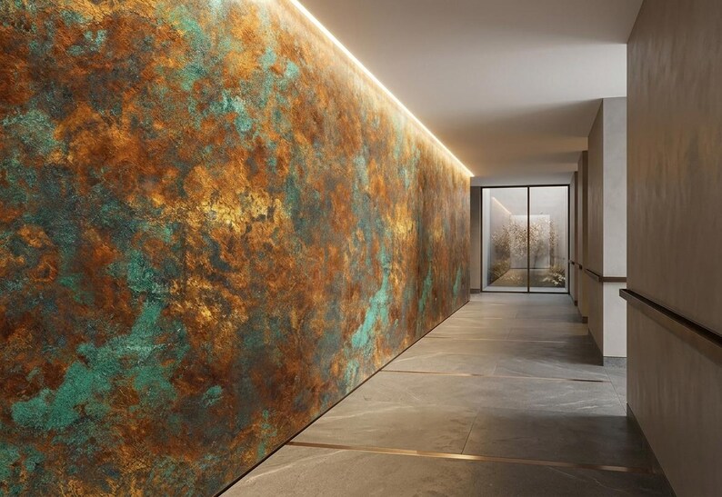 May include: An interior hallway with a textured wall featuring a blend of brown, gold, and teal colors. The wall is illuminated by a strip of light along the top. The floor is gray, and a glass door is visible at the end of the hall.