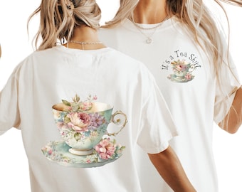 May include: White t-shirt with a floral teacup design on the back and the text "It's a Tea Shirt" on the front.