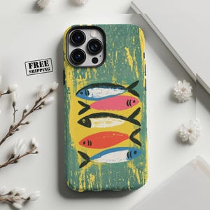 Puede incluir: Funda de teléfono con un diseño de peces coloridos. La funda presenta un fondo verde texturizado con un rectángulo amarillo en el centro. Cinco peces de varios colores, incluyendo azul, rosa, negro, rojo y azul, están dispuestos verticalmente.