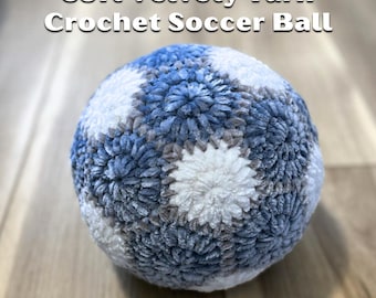 May include: A crocheted soccer ball made with soft, velvety yarn. The ball is blue, white, and gray.