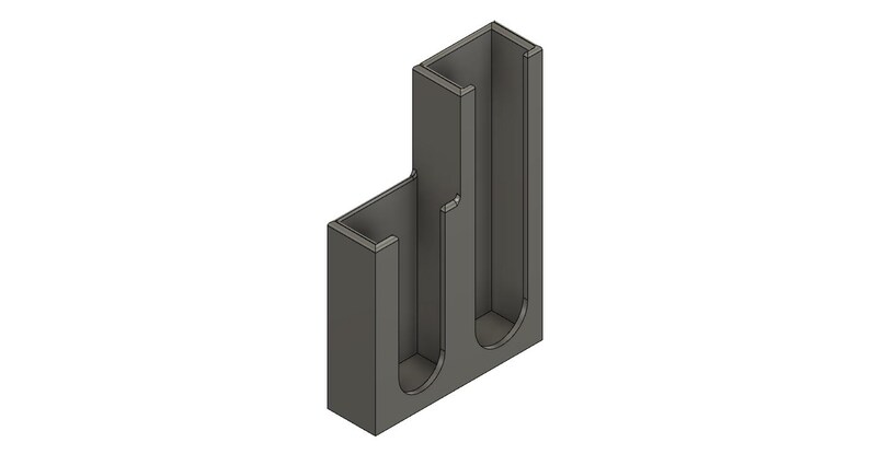 May include: A gray plastic organizer with two vertical slots for holding items. The organizer has a rectangular base and a vertical wall on one side.