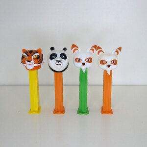 Puede incluir: Cuatro figuras de plástico de personajes de la película Kung Fu Panda, montadas en dispensadores de caramelos Pez amarillos, naranja, verde y naranja. Los personajes son Po el Panda, Tigresa, Tai Lung y Víbora.