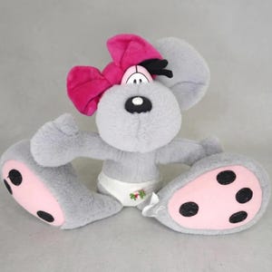 May include: A plush grey mouse toy featuring a large bright pink bow on its head, a white diaper with a small floral accent, and oversized feet with light pink soles and black circular paw pads. The mouse has a black nose and cartoonish eyes.