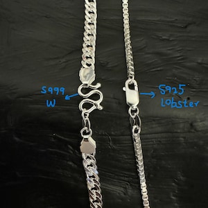 May include: Two silver necklaces with different chain styles. One features a curb chain with an S999 W clasp, and the other has a box chain with an S925 lobster clasp. Both necklaces are displayed against a dark background.
