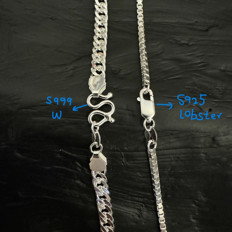 May include: Two silver necklaces with different chain styles. One features a curb chain with an S999 W clasp, and the other has a box chain with an S925 lobster clasp. Both necklaces are displayed against a dark background.