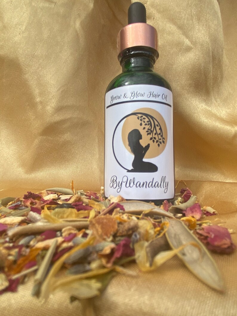 Pode incluir: Uma garrafa de vidro verde com um conta-gotas de cobre. A garrafa tem um r&oacute;tulo branco com o texto "Grow & Glow Hair Oil" e "By Wandally". O r&oacute;tulo tamb&eacute;m apresenta uma silhueta de uma pessoa com as m&atilde;os juntas em ora&ccedil;&atilde;o.