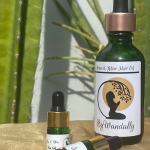 Pode incluir: Duas garrafas de vidro verde com tampas douradas e conta-gotas. A garrafa maior tem um r&oacute;tulo branco que diz "Grow & Glow Hair Oil By Wandally". A garrafa menor tem um r&oacute;tulo branco que diz "Sample".