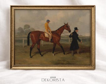 Puede incluir: Pintura ecuestre vintage enmarcada. La obra representa a un jinete con abrigo amarillo y gorra azul montando un caballo marrón, acompañado de un hombre con abrigo negro. La pintura tiene un marco dorado y un fondo de paisaje.
