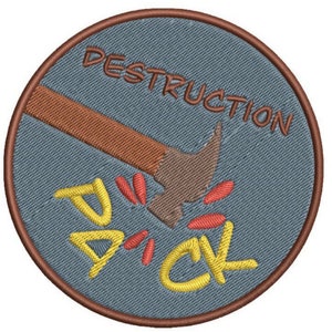 May include: A round, blue embroidered patch with a brown hammer smashing a yellow word "DICK" with red sparks. The text "DESTRUCTION" is written in brown around the top of the patch.