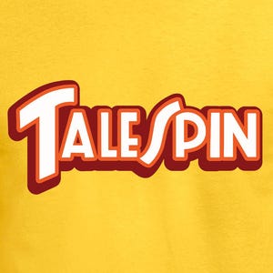 May include: A yellow t-shirt featuring the text "TALE SPIN" in a white font with a red outline. The shirt is made of a soft material and is being worn by a person.