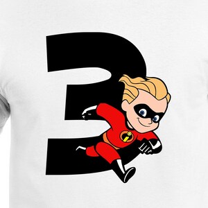 May include: White t-shirt featuring a large black number 3 with a cartoon image of Dash from The Incredibles. Dash is wearing a red and black superhero suit with a black mask and blonde hair. The shirt is made of a soft material.