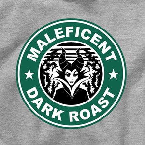 Puede incluir: Una sudadera con capucha gris con un logotipo circular verde que presenta una imagen de dibujos animados de Maléfica de La Bella Durmiente de Disney. El logotipo dice "Maleficent Dark Roast" en una fuente blanca.