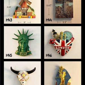 May include: A collection of decorative magnets featuring landmarks and cultural symbols. Includes a windmill scene (3" wide, 3.15" tall), a New York City skyline (2.2" wide, 3.07" tall), the Statue of Liberty, a London emblem, a skull, and a pharaoh.