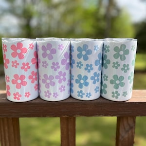 May include: Four stainless steel tumblers with a white background and a pattern of pink, purple, blue, and green flowers.