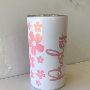 May include: White tumbler with a pink floral design and the name "Presley" written in pink cursive.