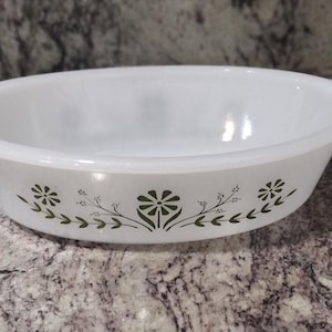 May include: White oval baking dish with a green floral design around the rim.
