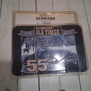 May include: A Schrade Old Timer 55th Anniversary commemorative display piece. The black and blue framed piece features a winter landscape with a deer and the years 1958 and 2013. The Schrade logo is visible.