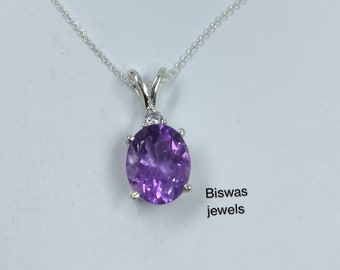 May include: A silver chain necklace with a pendant featuring a large, round, purple amethyst gemstone surrounded by smaller clear gemstones. The pendant is set in a silver setting. The text "Biswas jewels" is visible in the lower right corner of the image.