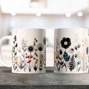 May include: Two white ceramic mugs with a floral design. The mugs feature a variety of flowers and plants in shades of black, white, brown, red, and teal.