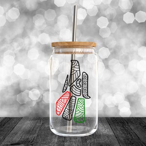 May include: A clear glass jar with a wooden lid and a metal straw. The jar has a black and white design with red, green, and white accents. The design is a stylized tree with geometric shapes.