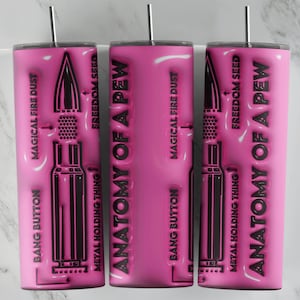 May include: Three pink tumblers with black text and graphics. The text reads "Anatomy of a Pew" and includes the words "Bang Button", "Magical Fire Dust", "Metal Holding Thing", and "Freedom Seed".