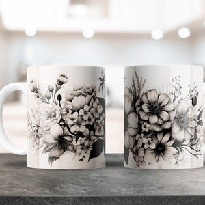 May include: Two white ceramic mugs with black and white floral designs. The mugs have a handle on the right side.