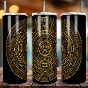 May include: Three black stainless steel tumblers with a gold Aztec calendar design. The design features a circular pattern with intricate details and a central sun face.