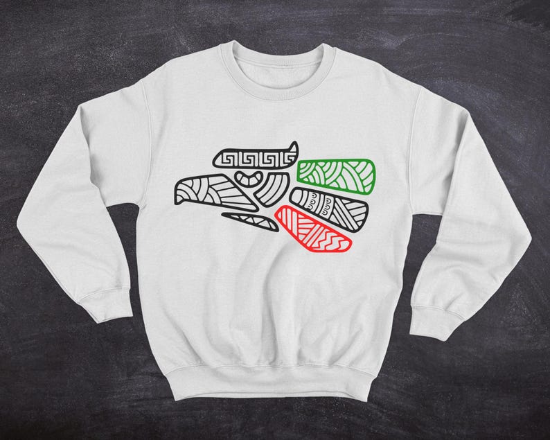 May include: White sweatshirt with a black and white outline of an eagle head with red and green accents. The eagle head is a stylized design with geometric patterns.