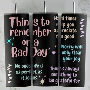 May include: Three black stainless steel tumblers with inspirational quotes in pink, blue, and white lettering. The quotes are: "Things to remember on a bad day", "Hard times help you appreciate the good", and "Worry will only steal your joy".