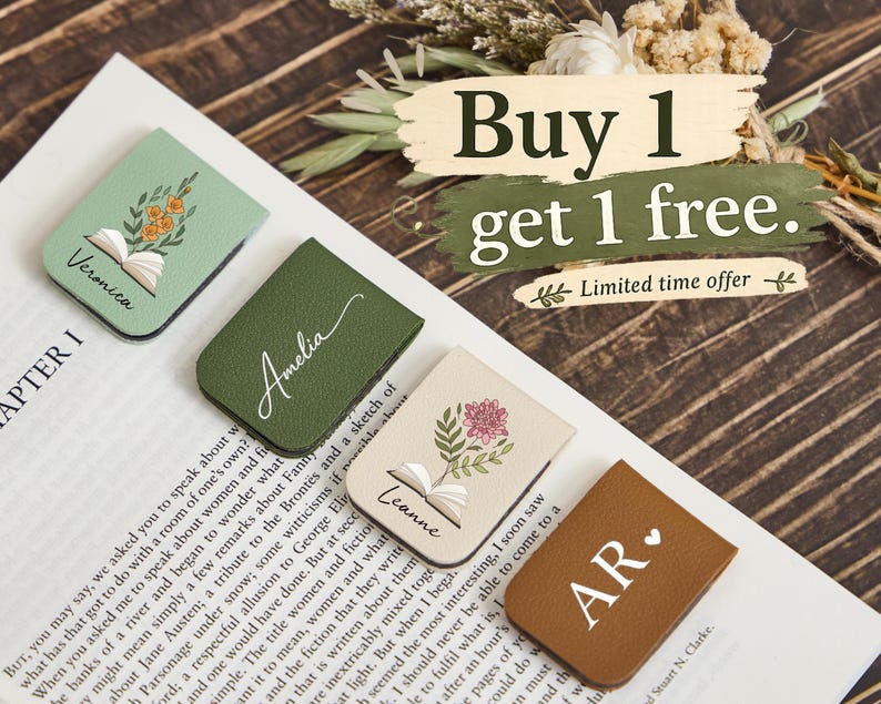 May include: Four rectangular magnetic bookmarks in sage green, forest green, cream, and brown. The sage bookmark features an open book with orange flowers and the name Veronica. The cream bookmark shows an open book with a pink flower and the name Leanne. The forest green bookmark has the name Amelia, and the brown bookmark displays the initials AR with a heart.