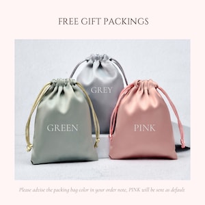May include: Three satin drawstring gift bags in green, gray, and pink. Each bag is labeled with its color. The text "FREE GIFT PACKINGS" is at the top of the image.