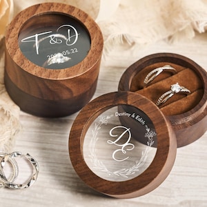 May include: Two wooden ring boxes with clear lids. One box has the initials "T&D" and the date "2023.05.22" engraved on the lid. The other box has the names "Destiny & Edith" and the initials "D&E" engraved on the lid.