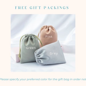 May include: Three drawstring gift bags in pink, green, and gray. The bags are made of a soft, fabric material. *Please specify your preferred color for the gift bag in order note*