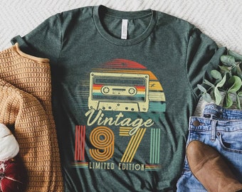Puede incluir: Una camiseta verde con un gráfico de cinta de casete vintage y el texto "Vintage 1971 Limited Edition".