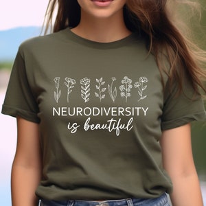 May include: A green t-shirt with a white graphic of flowers and the text "Neurodiversity is beautiful".