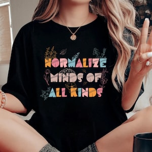 May include: Black t-shirt with the text "Normalize Minds of All Kinds" in colorful letters with floral accents.