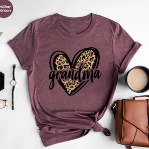 May include: A heather maroon t-shirt with a leopard print heart and the word "grandma" printed on it.