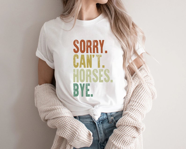 May include: A white t-shirt with a vintage-style graphic that reads "SORRY. CAN'T. HORSES. BYE."