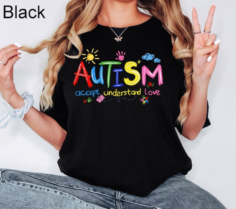 May include: Black t-shirt with a colourful graphic that says "AUTISM accept understand love".