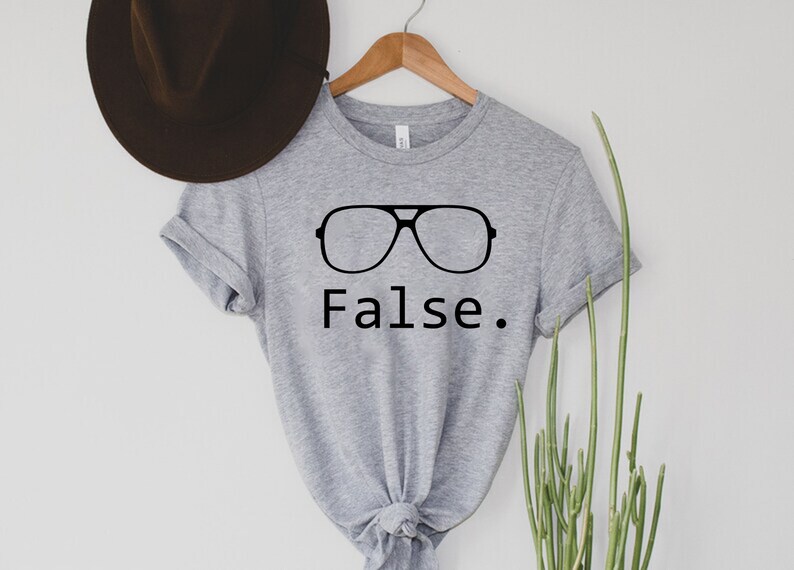 May include: Grey t-shirt with a black graphic of sunglasses and the word "False."