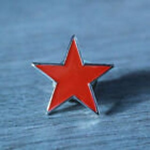 May include: A red enamel star pin with a silver metal border.