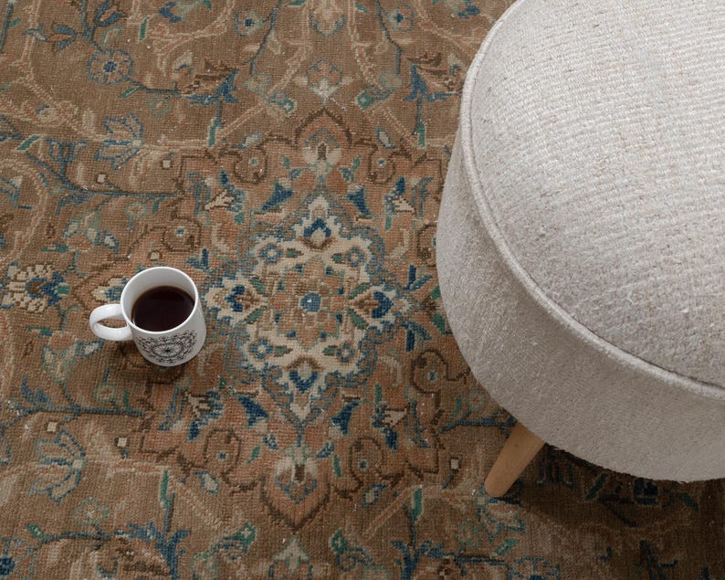 A Close-up of vintage persian rug, Warm brown background with muted blue floral and medallion details. 7.5 x 9.9 feet