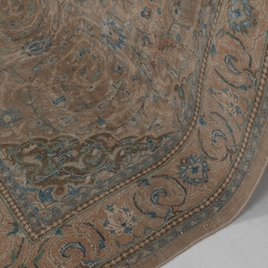 A Close-up of vintage persian rug, Warm brown background with muted blue floral and medallion details. 7.5 x 9.9 feet